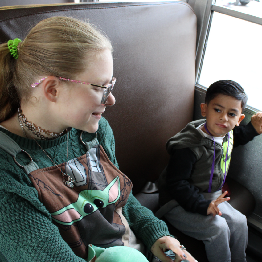 two students sitting on a bus 