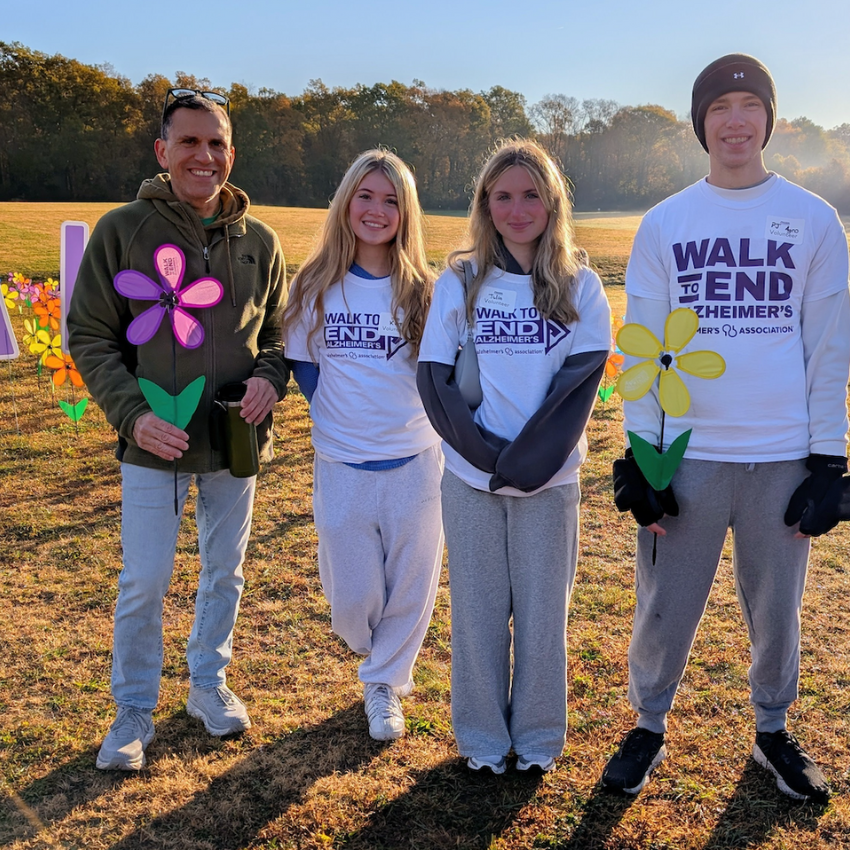 four people wearing white shirts and holding faux flowers 