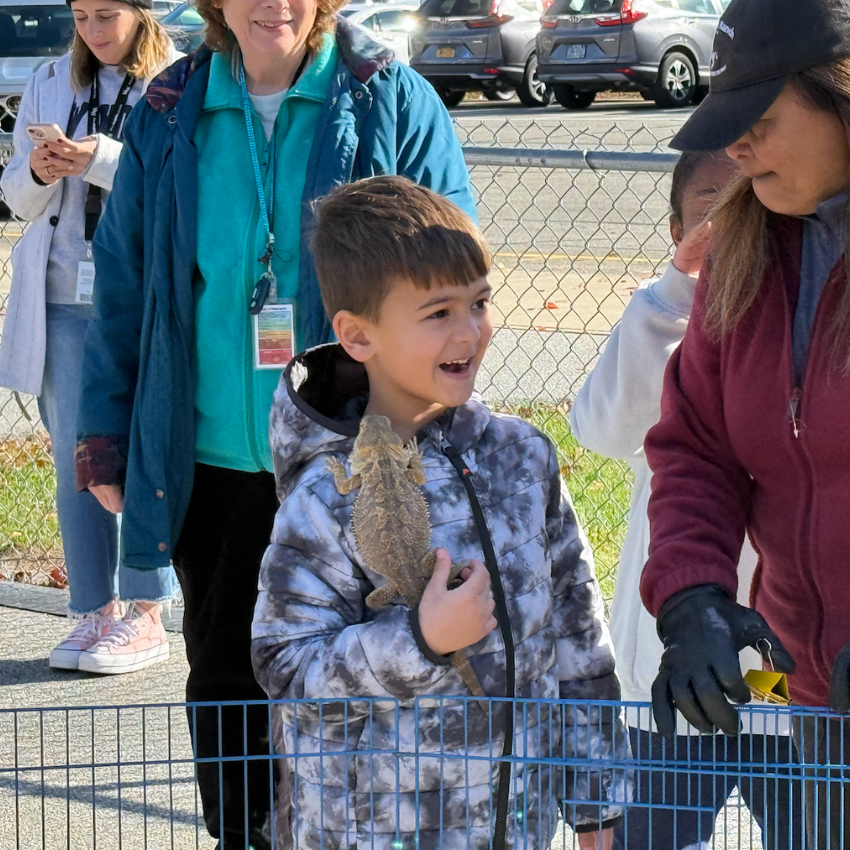 student holding an iguana