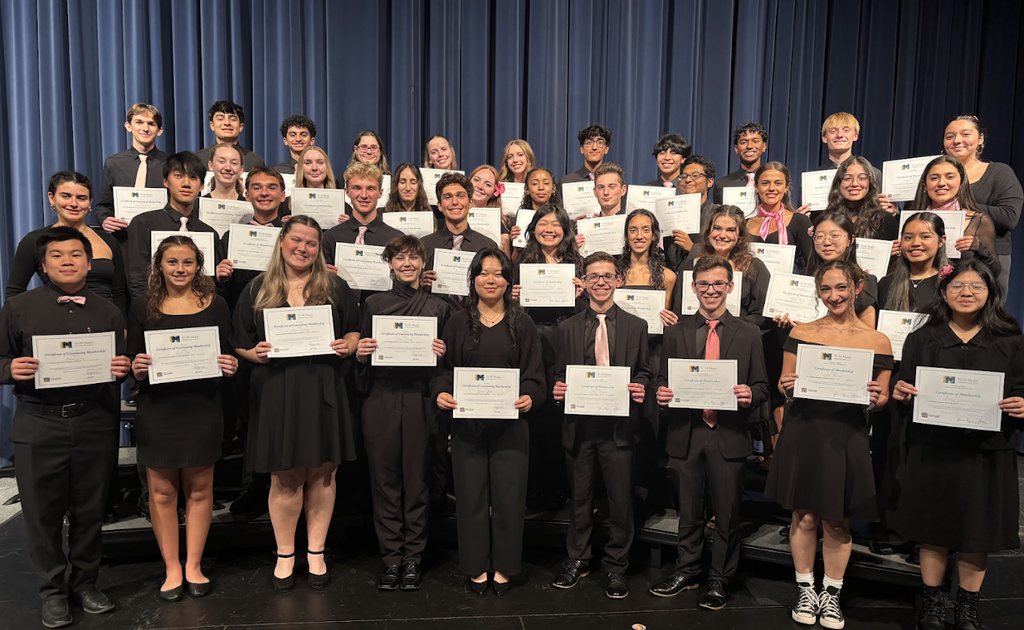 students all dressed in black holding white certificates