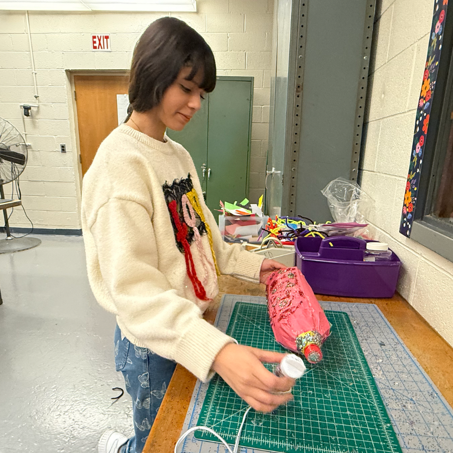 student decorating pink bottle rocket 