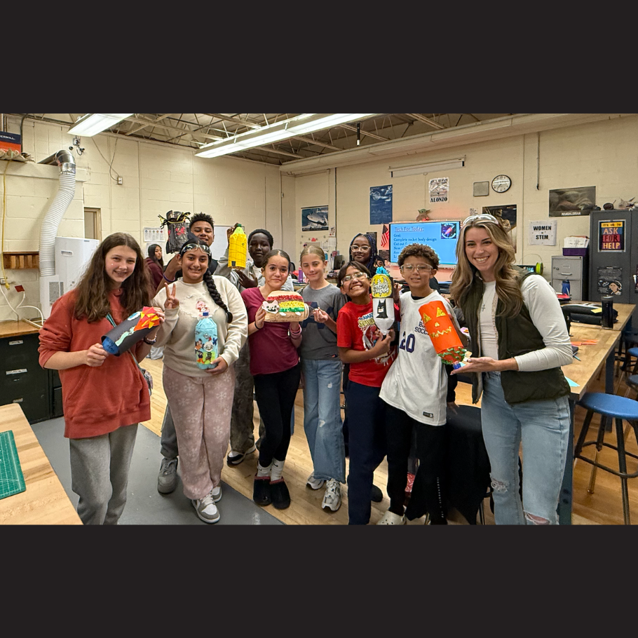 students and teacher holding bottle rockets 