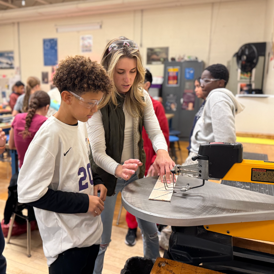 two people standing in front of a cutting machine 