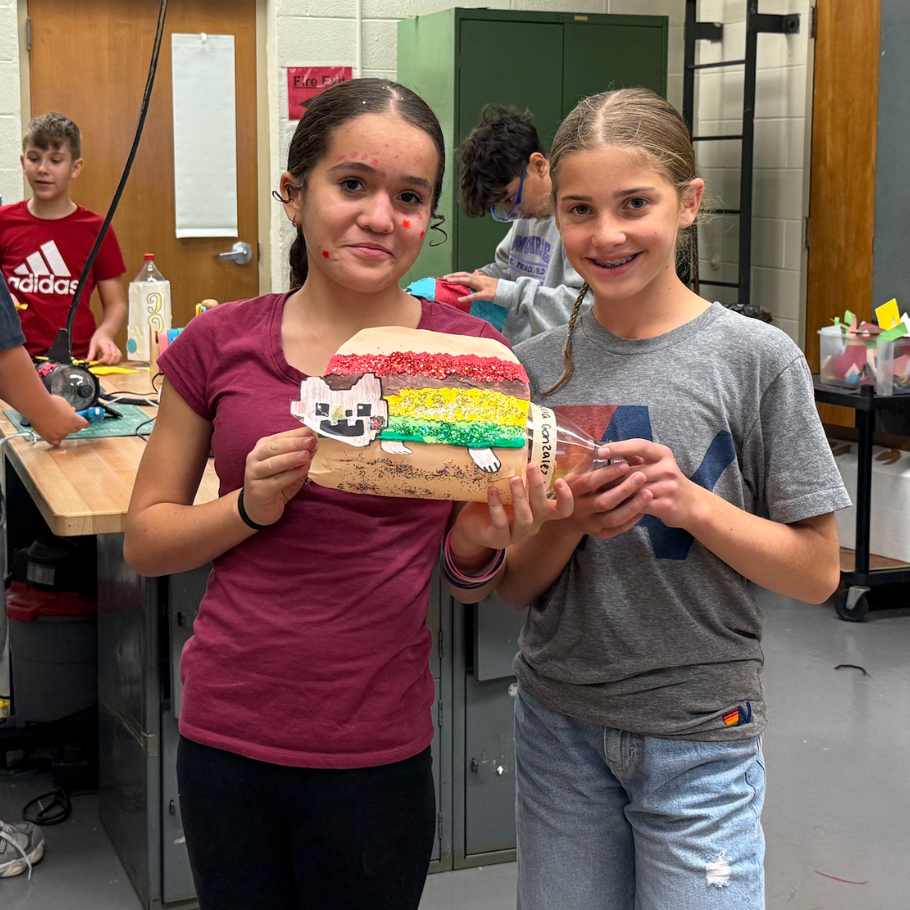 two students holding red, yellow and green rocket 