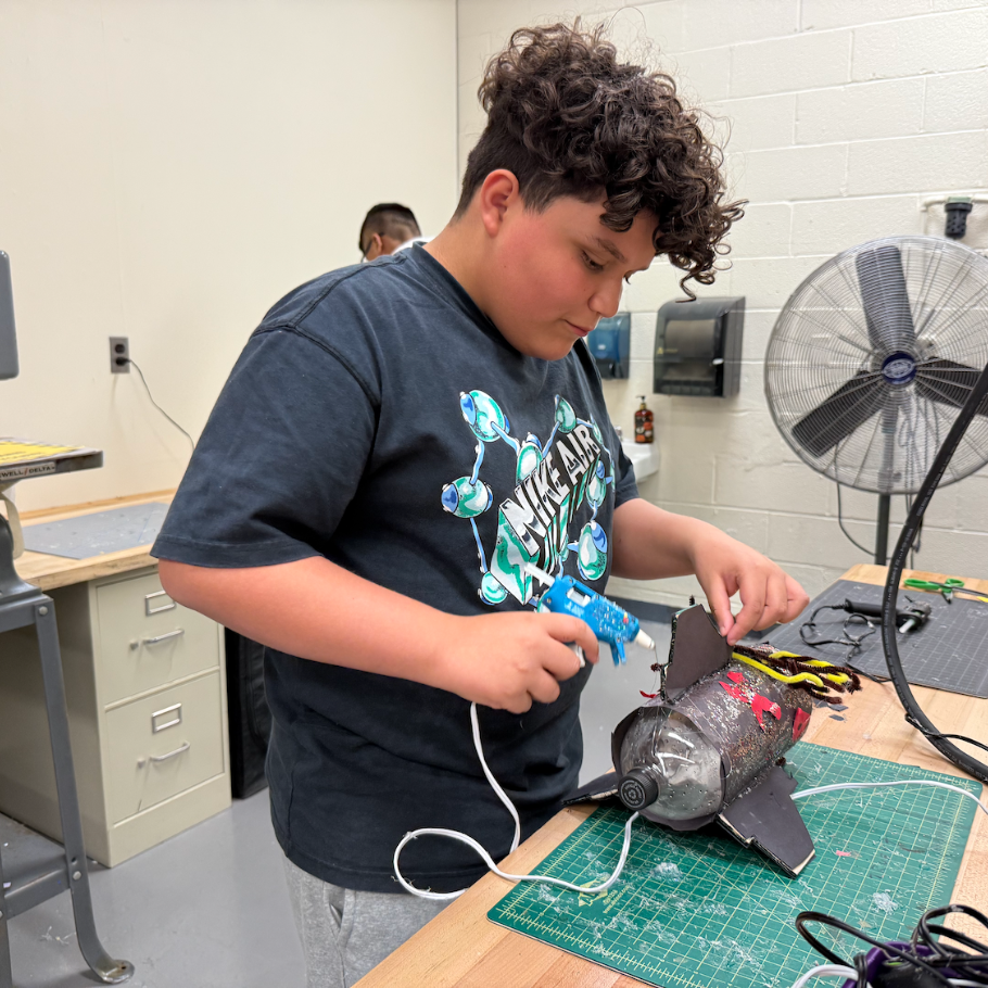 student gluing bottle rocket 