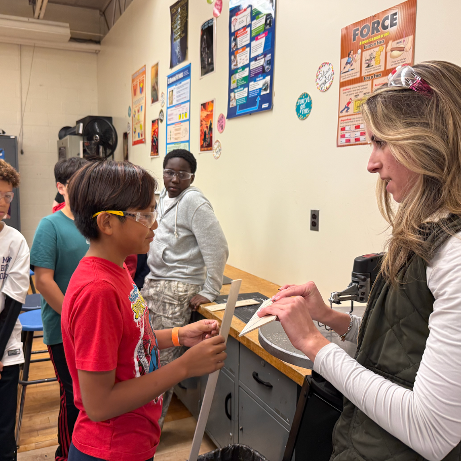 student and teacher in front of a cutting board 