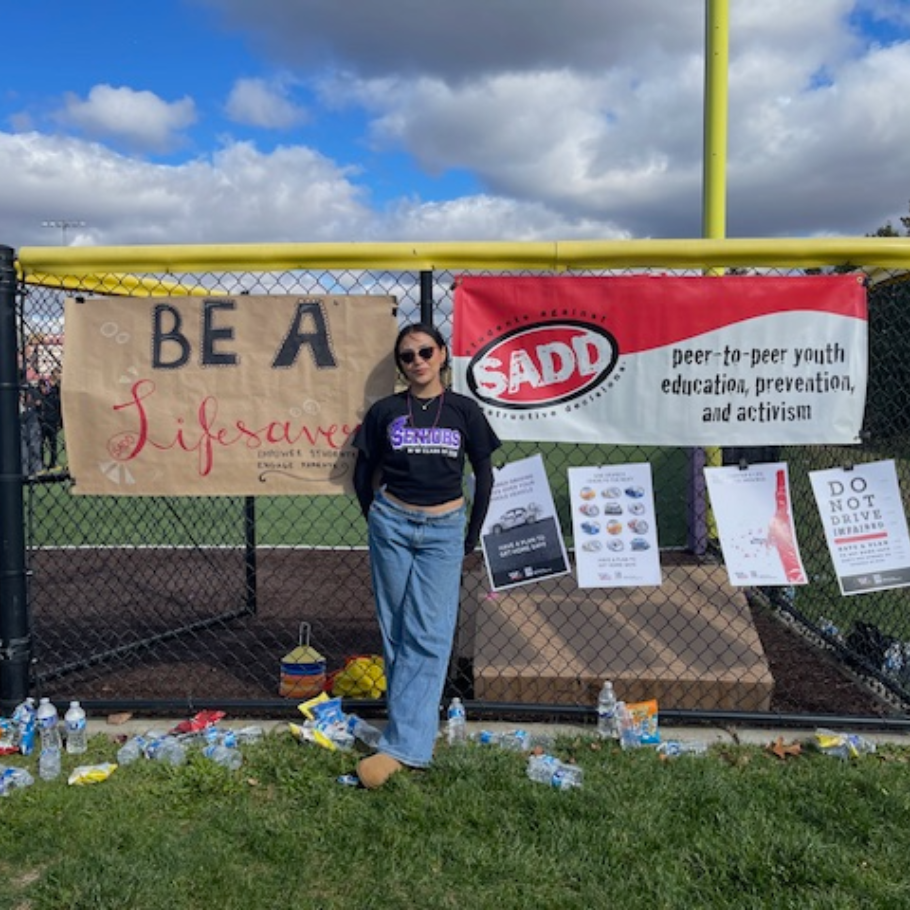 student standing in front of a yellow pole and a red sign 