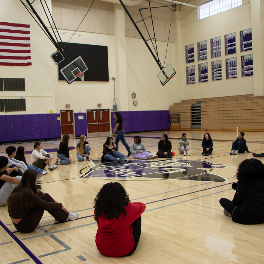 students sitting on the floor in gym 