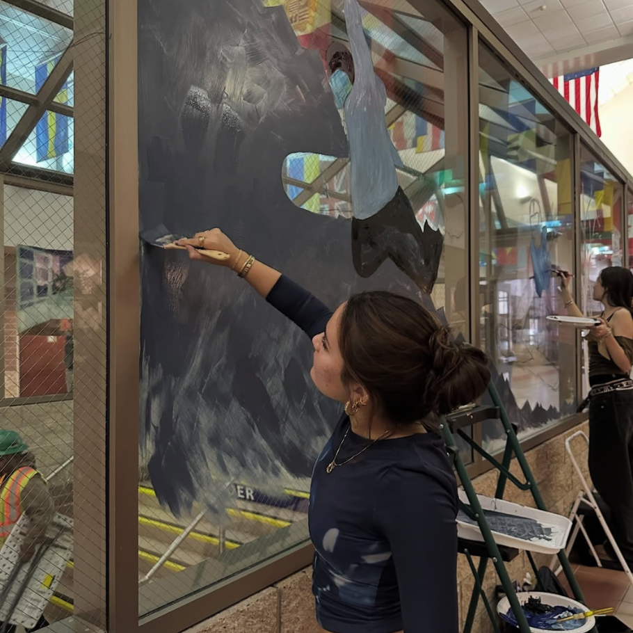 student painting a window
