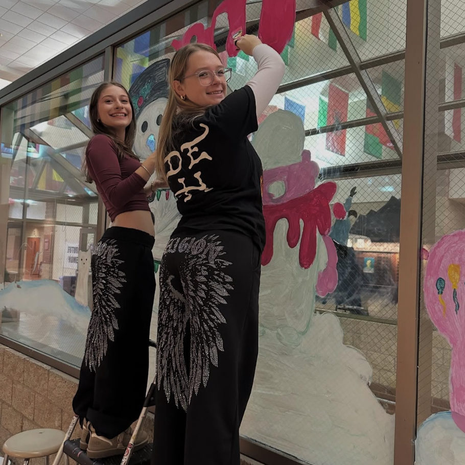 two students painting a window