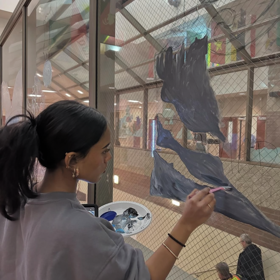 student painting a window