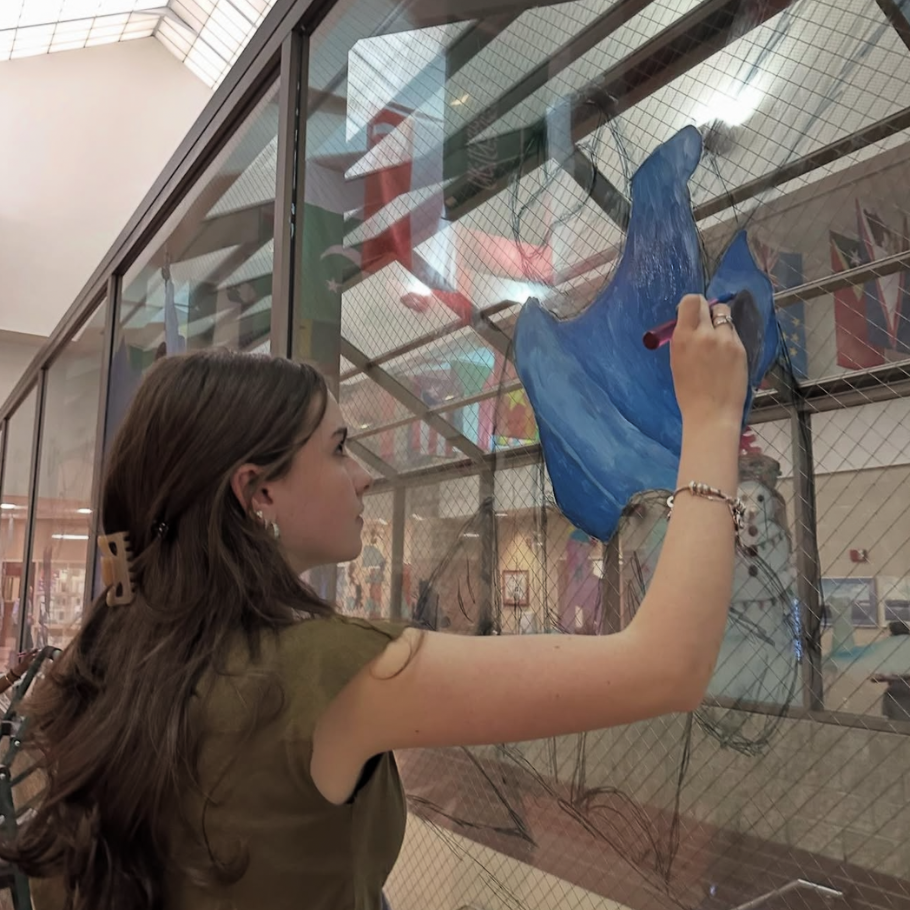student painting a window