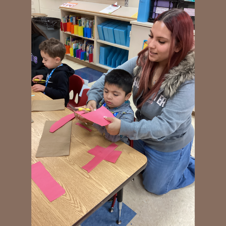 student cutting a red piece of paper