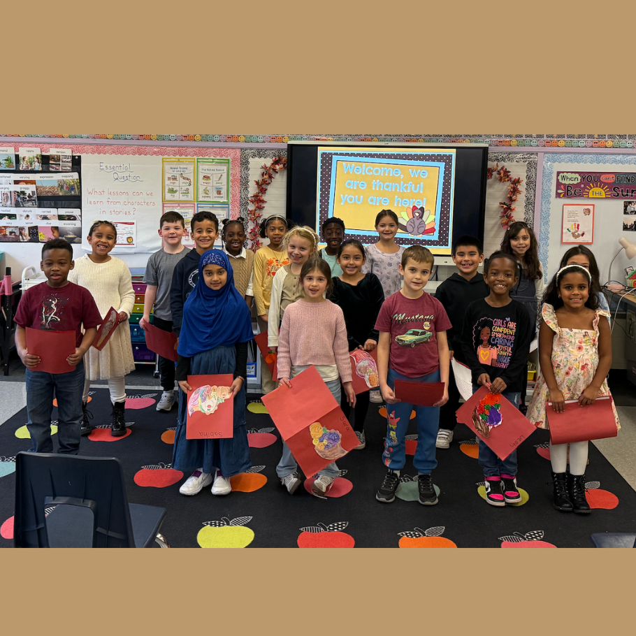 class smiling holding orange folders