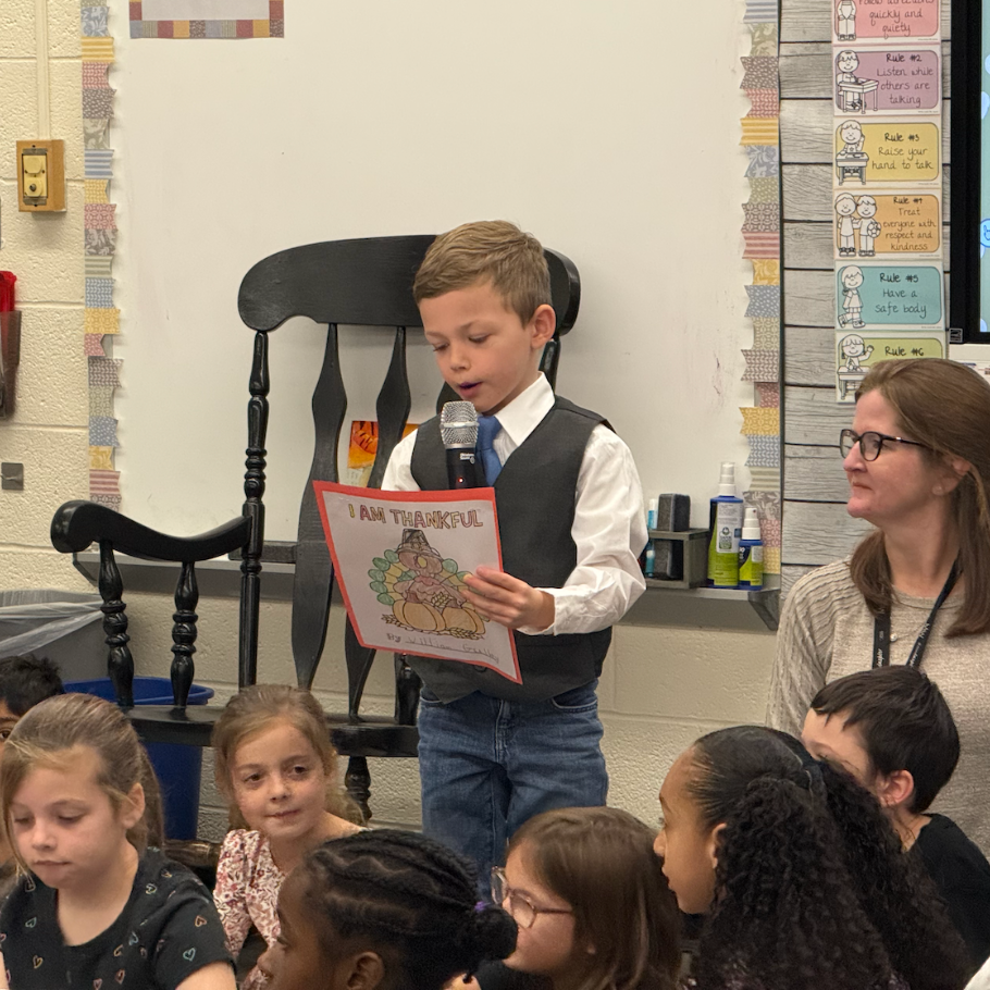 student reading in a class holding a read paper