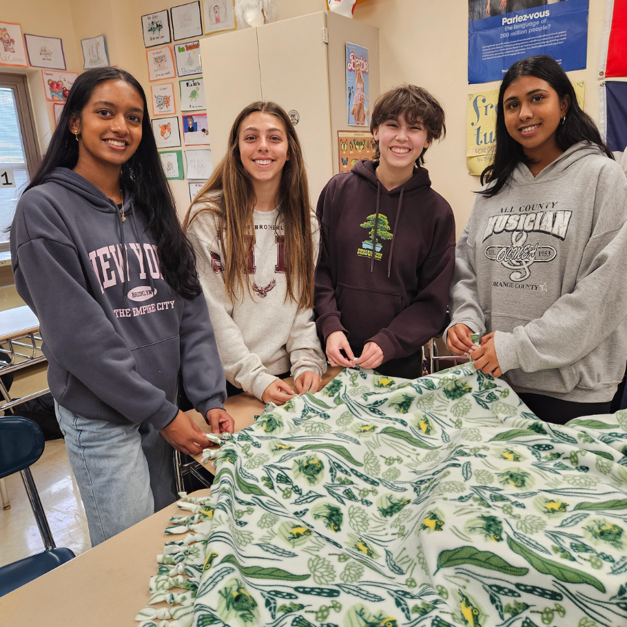students holding colorful blanket