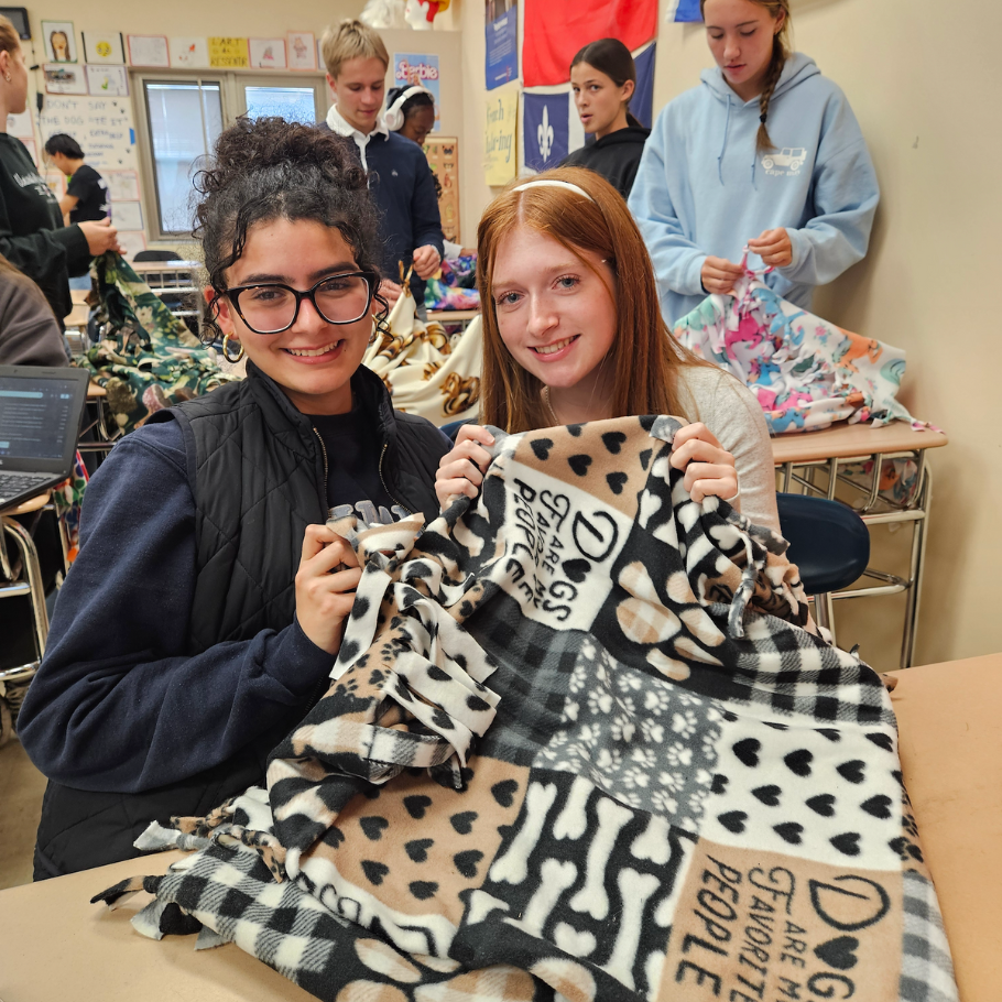 students holding colorful blanket
