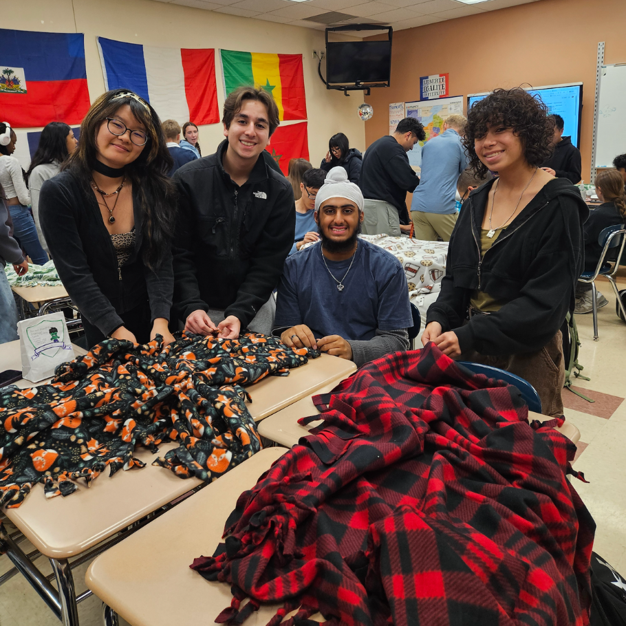 students holding colorful blankets