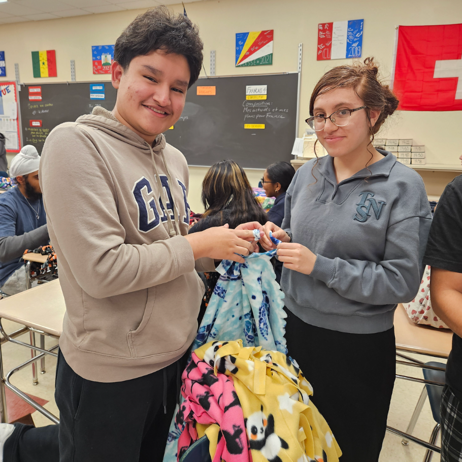 students holding colorful blankets