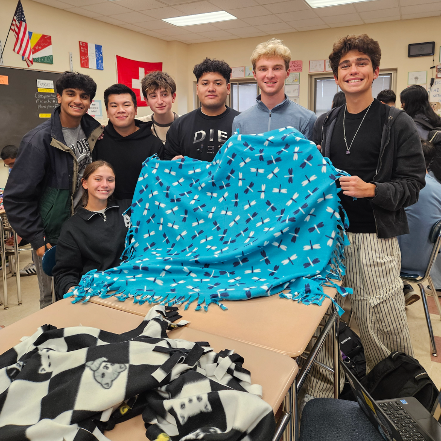 students holding colorful blanket
