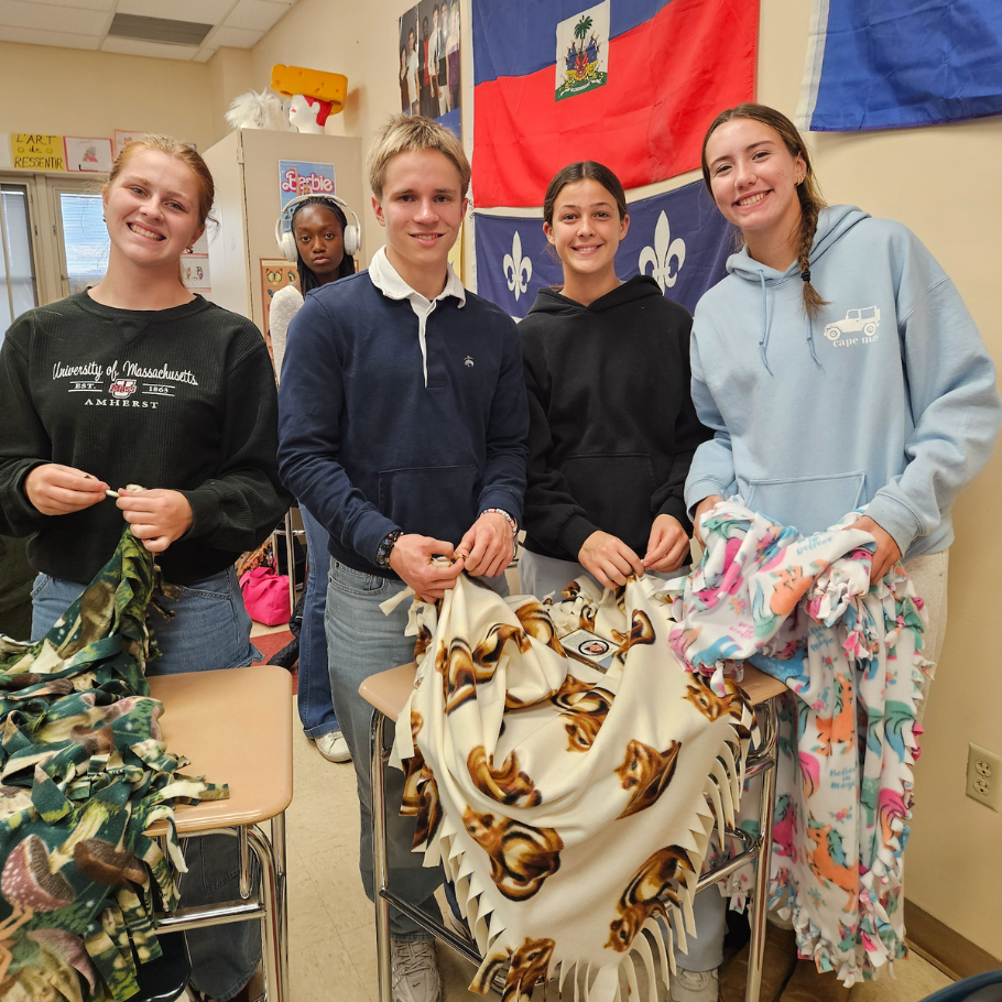 students holding colorful blanket