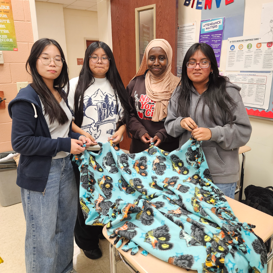 students holding colorful blanket