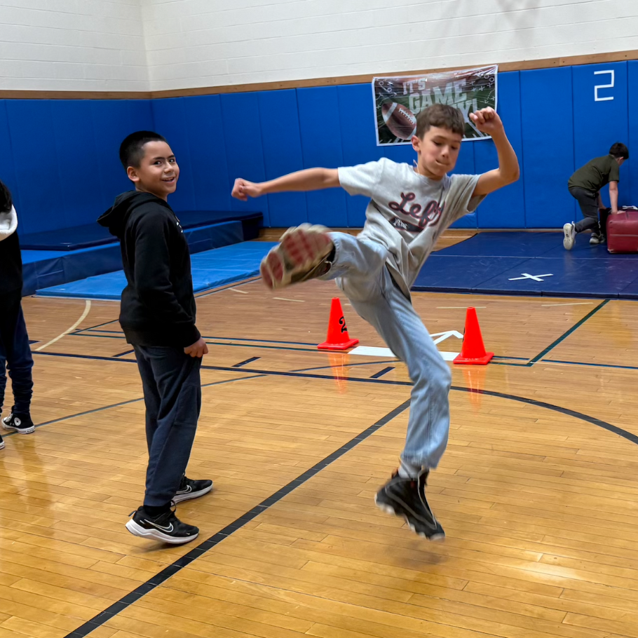 Student kicking with black sneakers in gym 