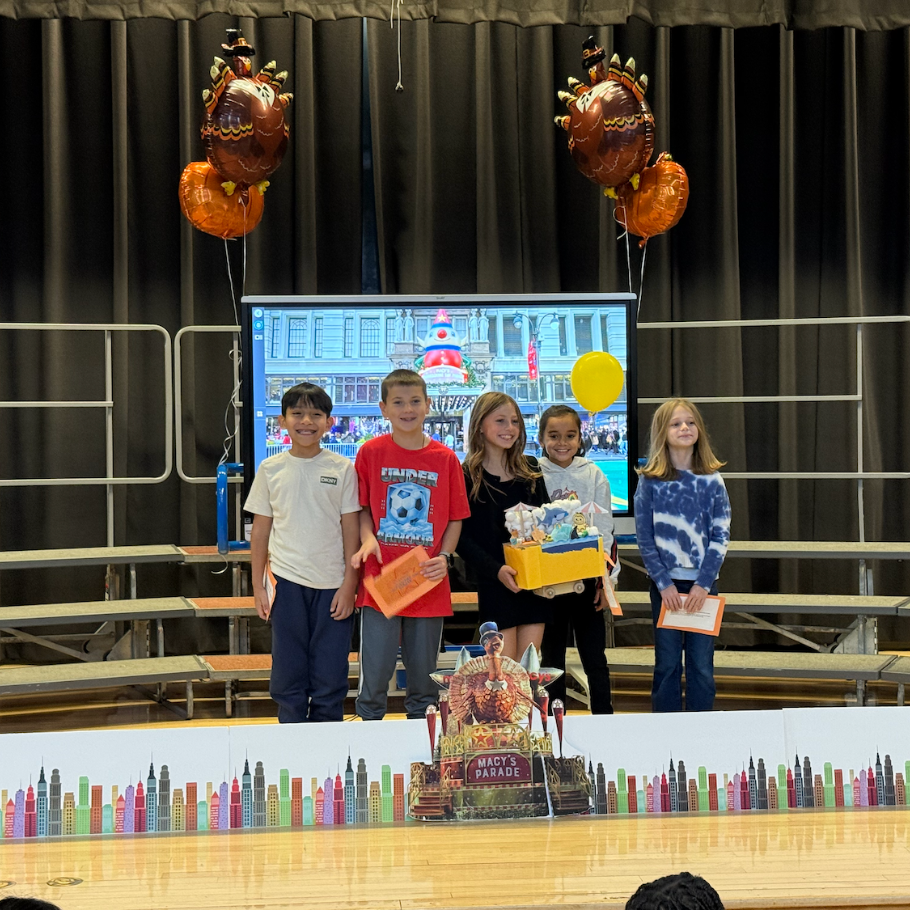 students standing on stage with turkey balloons