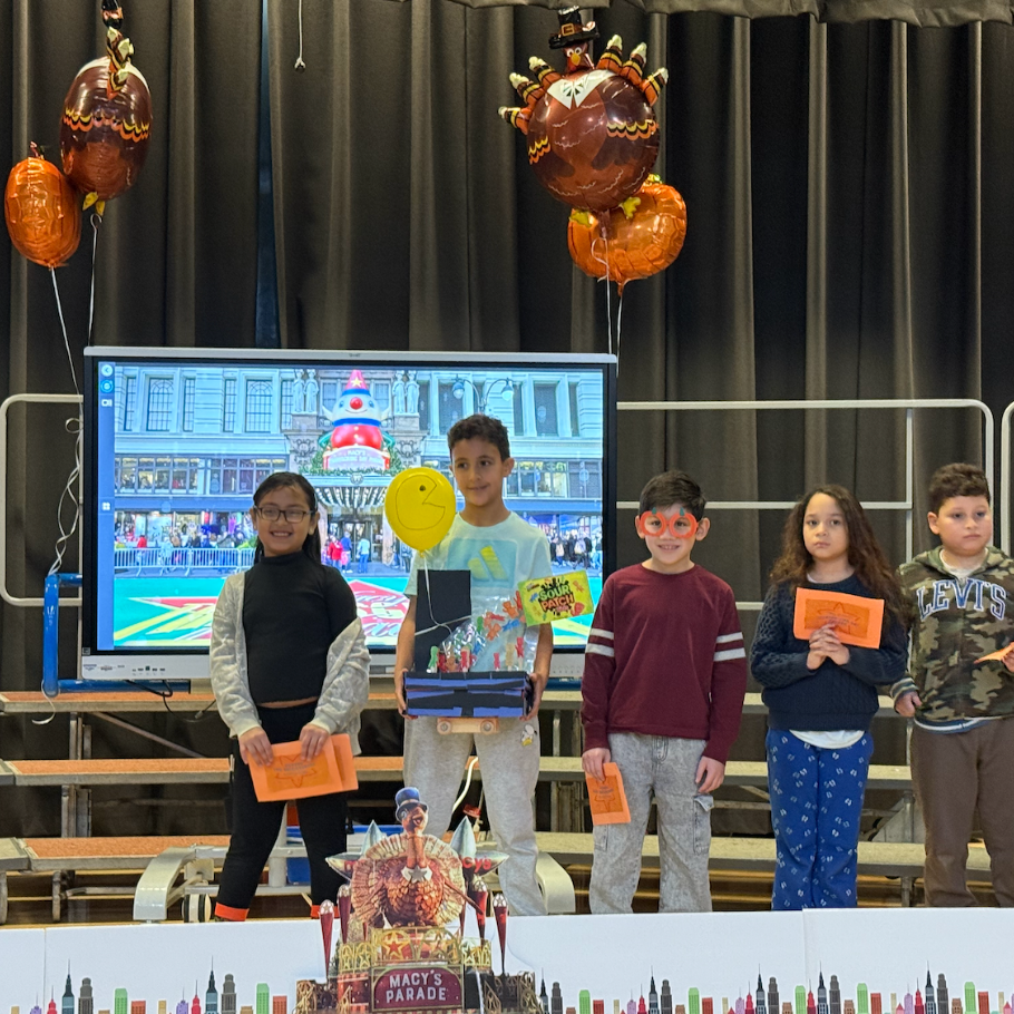 students standing on stage with turkey balloons