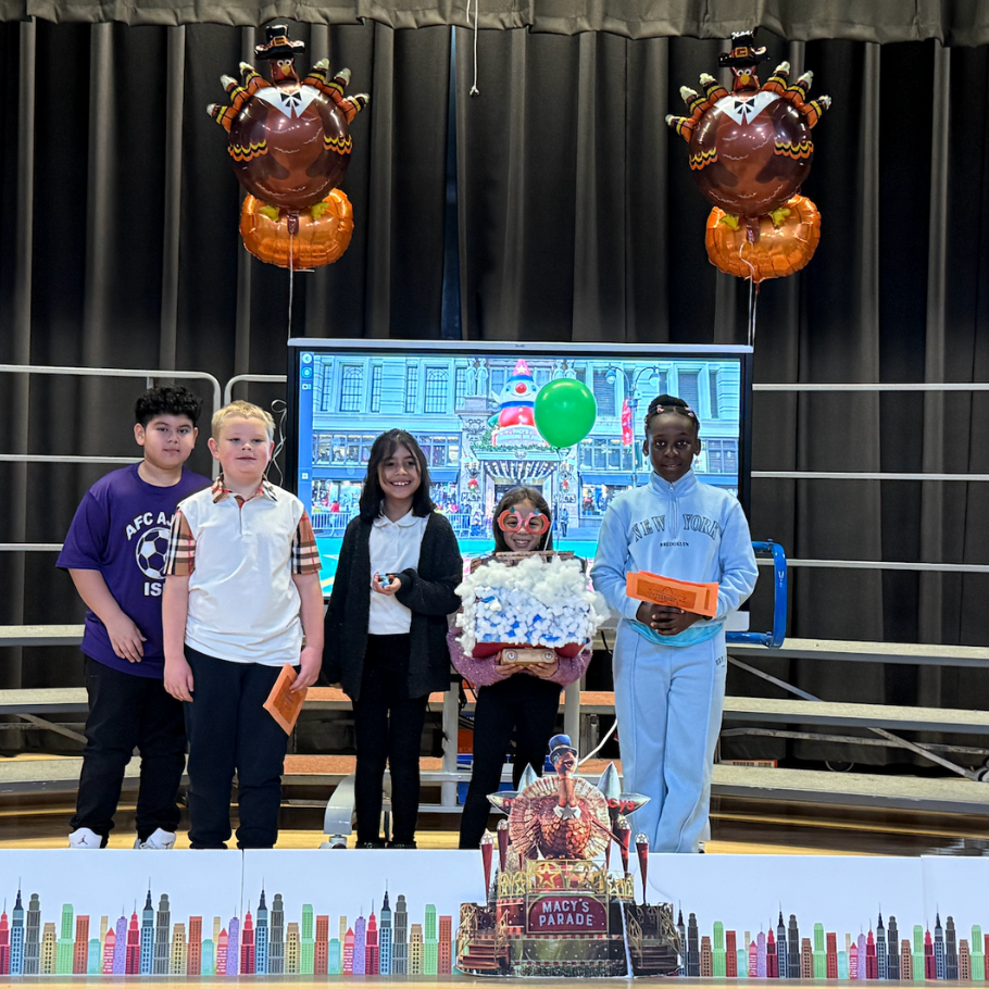 students standing on stage with turkey balloons