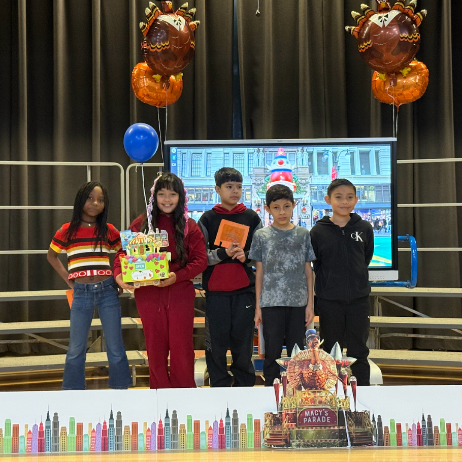 students standing on stage with turkey balloons