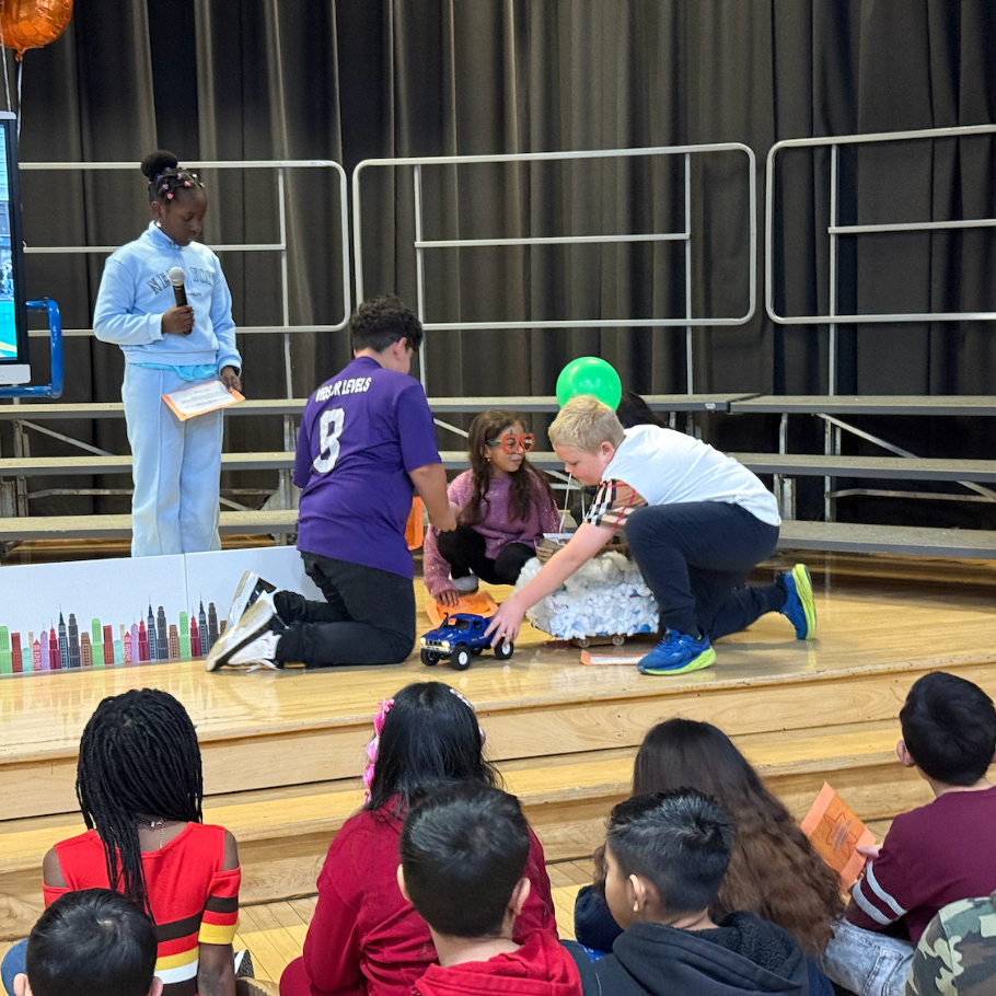 students standing on stage with turkey balloons