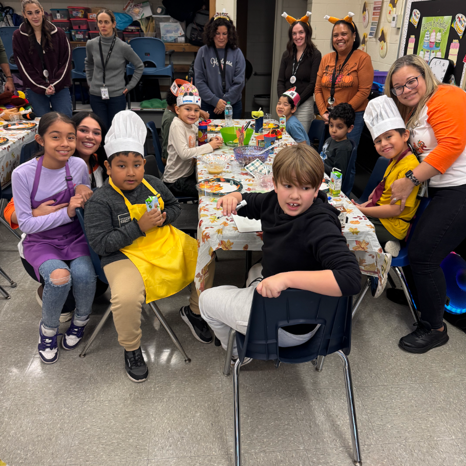 students sitting at a table with table cloth with leaves
