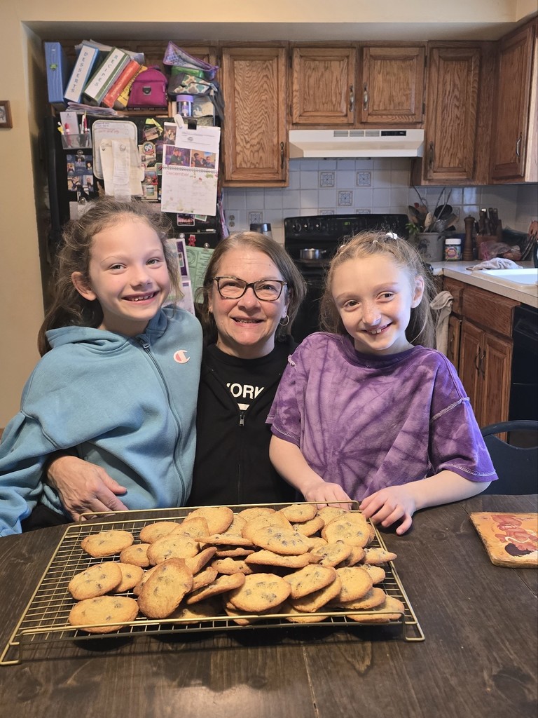 students and their nana with a tray of cookies they baked during the snow day