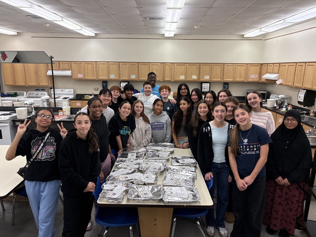 students stand around the lasagnas they made for the senior citizens