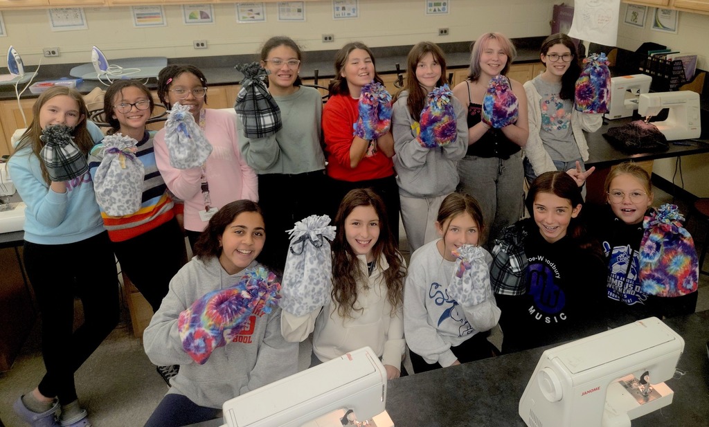 sewing club members with the hats they made for families in need