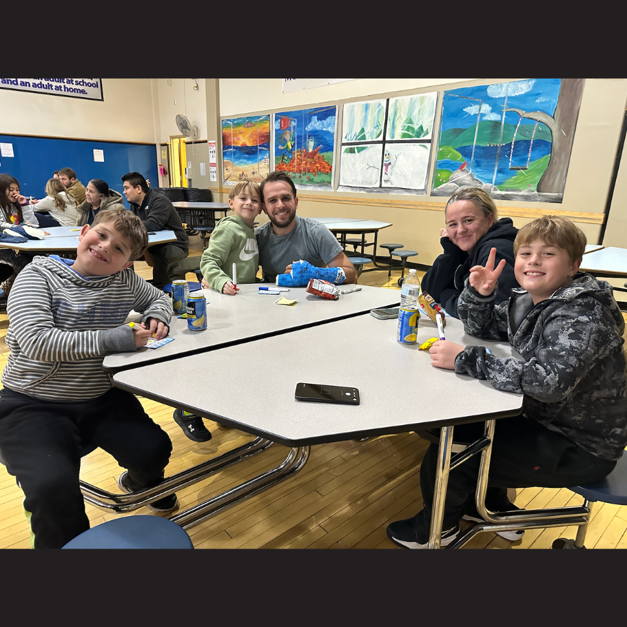 family sitting around a blue table 