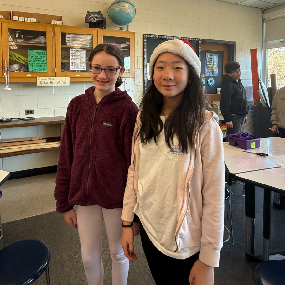 two girls wearing white and red hats and pink sweaters