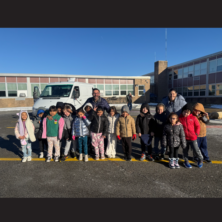 teachers standing outside with class in front of white van 