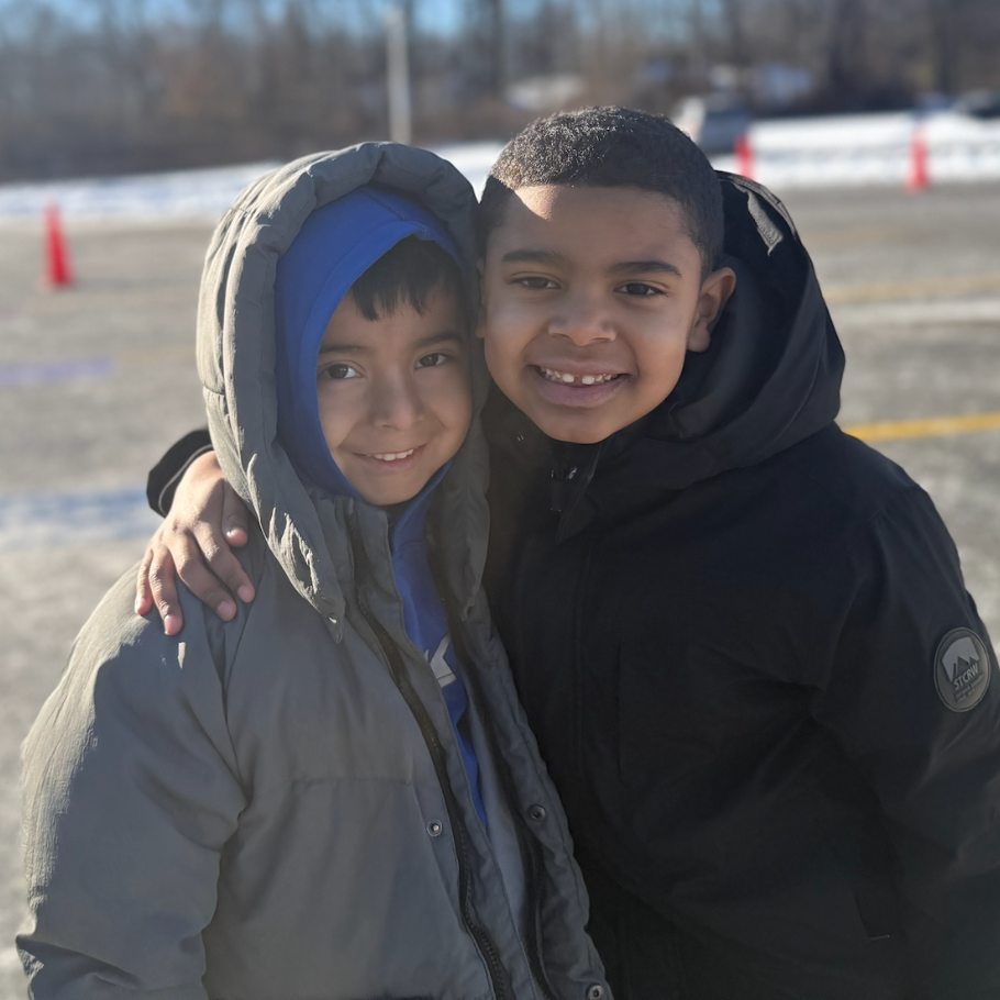 two students in blue and black coat smiling