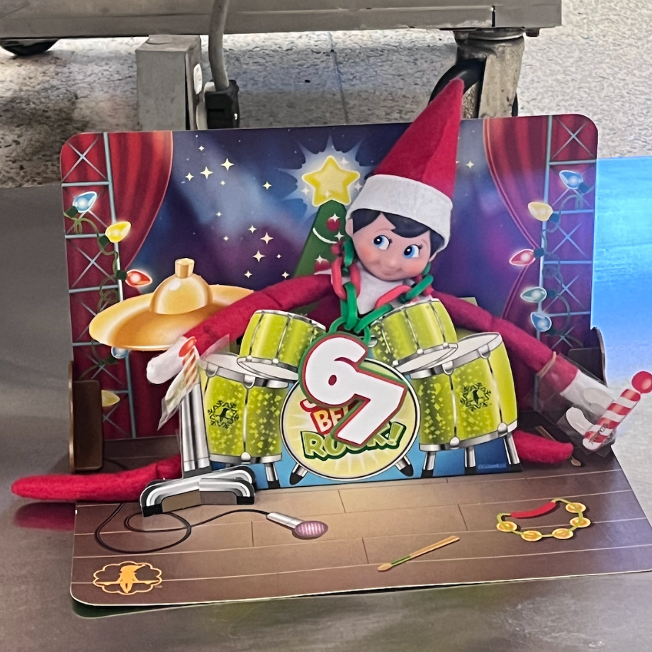 elf toy with 6 7 in front of it