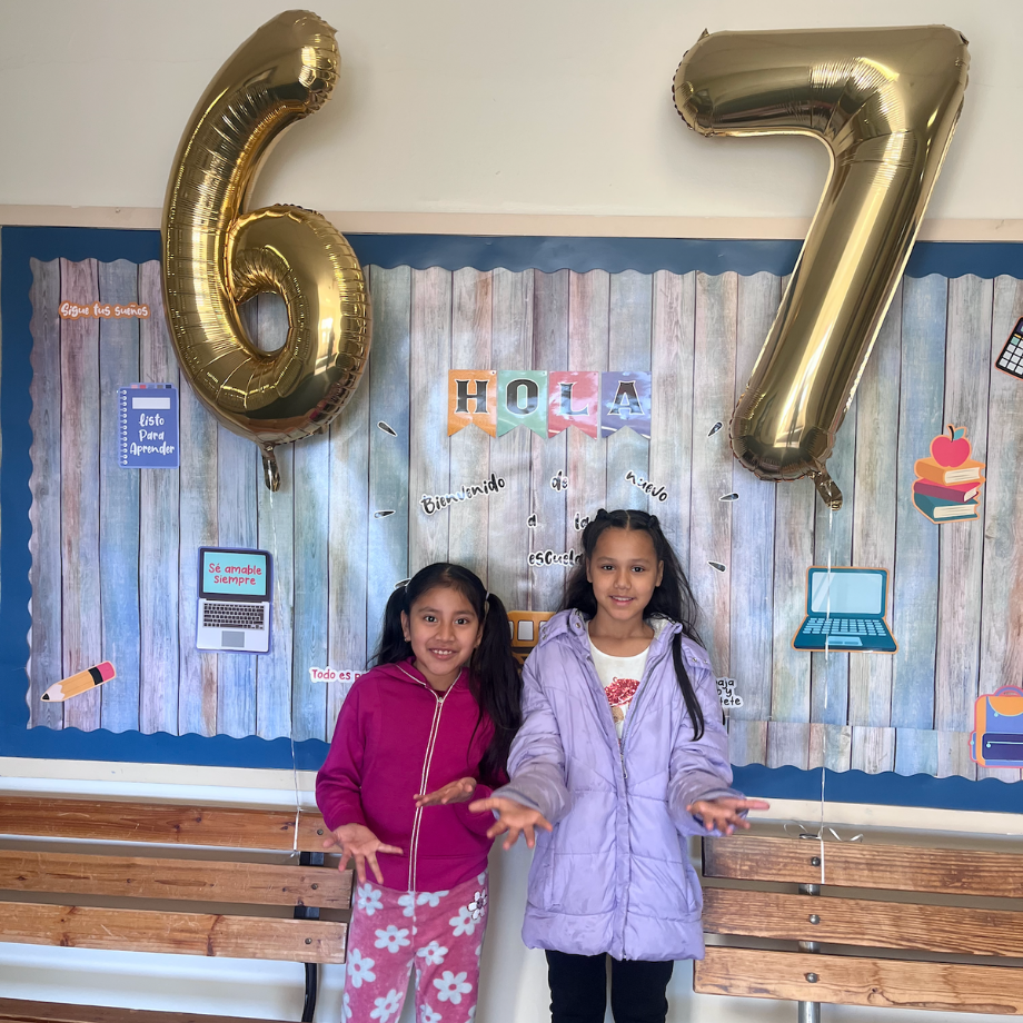 two students standing in front of balloons that says 6 and 7