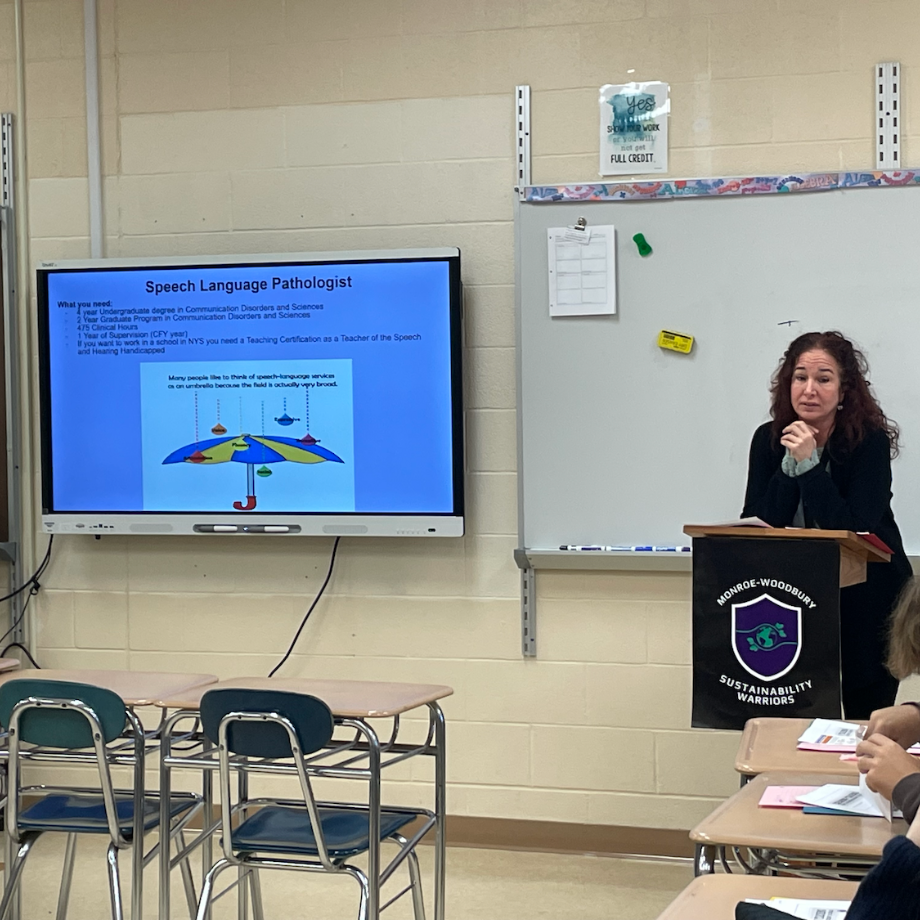 woman standing in front of a black podium, speech language pathologist 