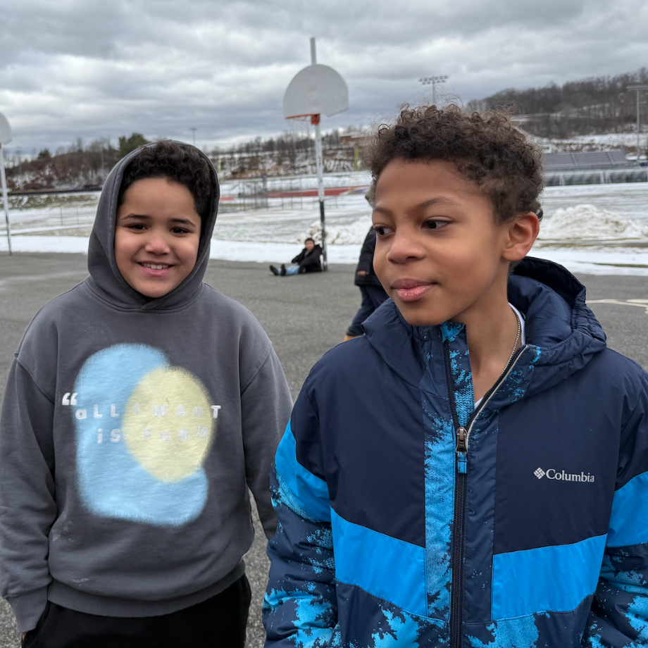 two students with blue and grey coats standing outside 