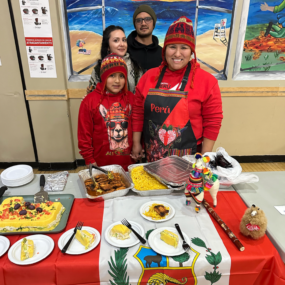 four people wearing red in front of a food table