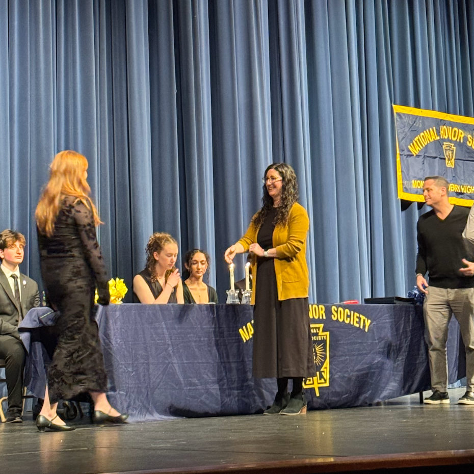 students walking across black stage