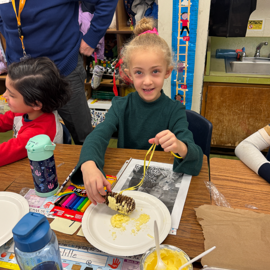 student holding bird feeder