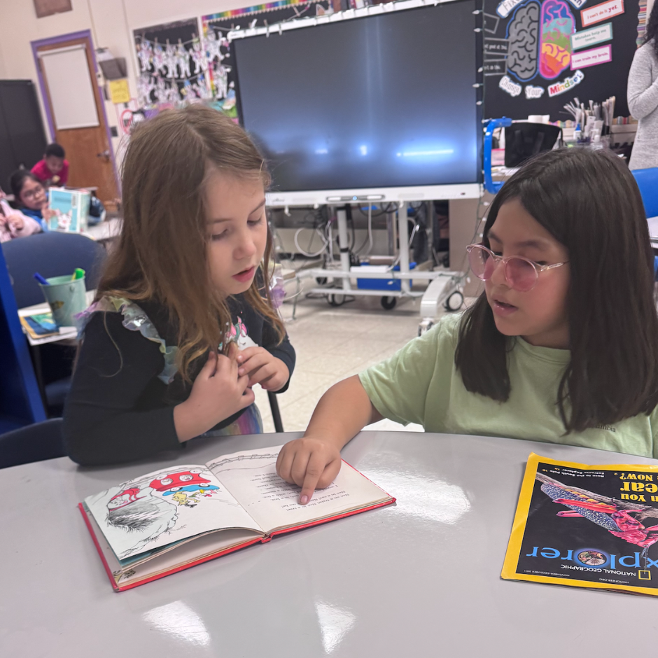 two students reading a book
