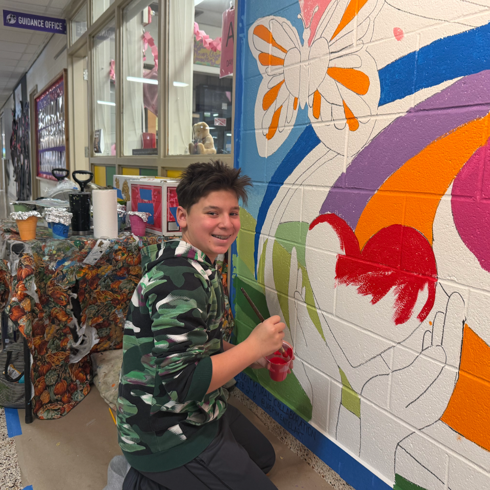 student holding paint brush 