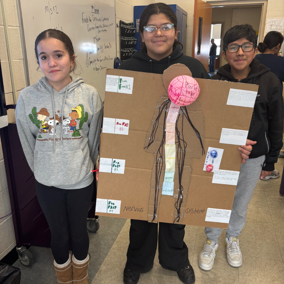 three students holding a poster board